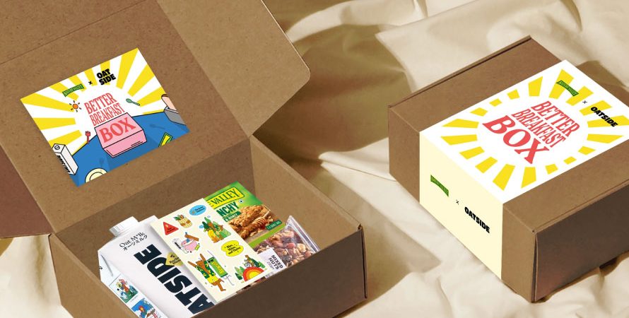 Two open brown cardboard boxes with 'Better Breakfast Box' branding display an assortment of breakfast items, including Nature Valley bars and a milk carton, designed by a creative digital marketing agency in Malaysia.